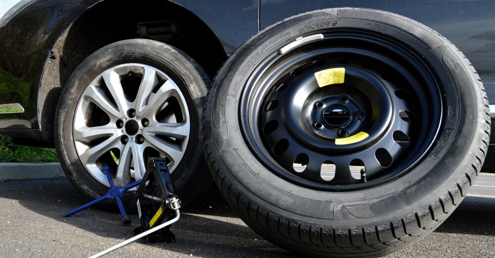 路上でのエアーコンプレッサーを用いたタイヤ交換中の様子